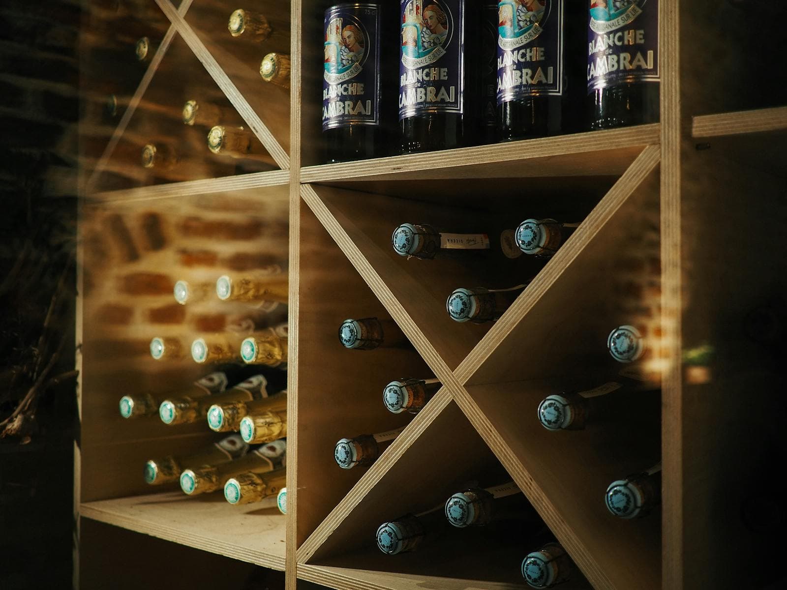 Diamond-cube custom wine cellar racking pattern in a brick-lined private cellar room